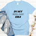 a t - shirt that says in my girl dad era next to a pair of